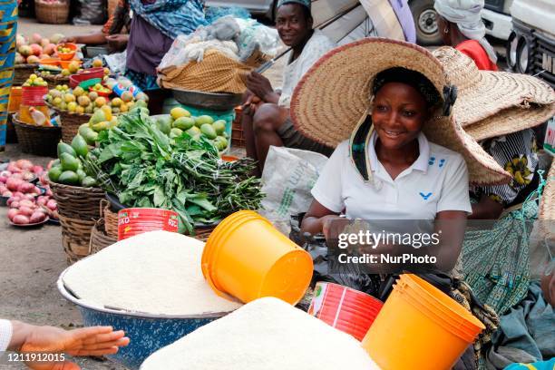 Woman without facemask receives money from customer inside Mile 12 Food Market in Lagos, Nigeria on Monday, May, 4 2020. In order to cushion the...