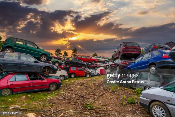 old damaged cars on the junkyard waiting for recycling - junkyard stock pictures, royalty-free photos & images