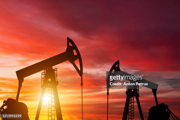 oil pump on a sunset background. world oil industry - gas pump fotografías e imágenes de stock