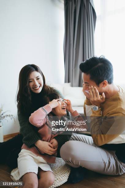 happy young family having fun at home while father and daughter making silly faces together - quirky couple stock pictures, royalty-free photos & images