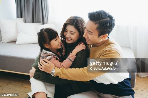 portret van een jonge moeder en vader die kwaliteitstijd besteden die met hun aanbiddelijke dochter thuis verbinden - chinese kid stockfoto's en -beelden