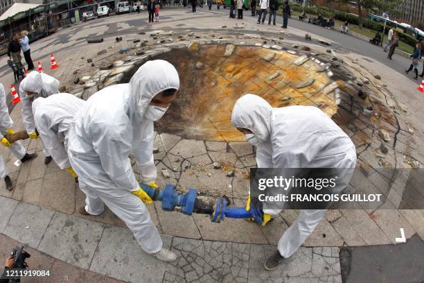 Antinuclear activists pose next to British artist Julian Beever pavement painting of a crater at Place Raoul Dautry infront Tour Montparnasse in...