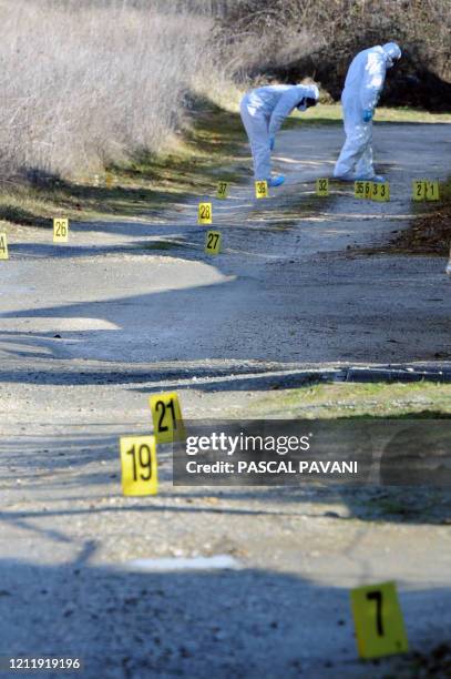 Des experts de la brigade scientifique examinent des traces sur un chemin de la commune de Bouloc, le 15 février 2011, où des effets personnels de...