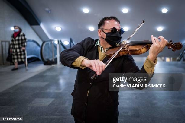 Street musician wearing a face mask performs on his violin in an underpass in Bratislava on May 6 amid the novel coronavirus COVID-19 pandemic. - The...