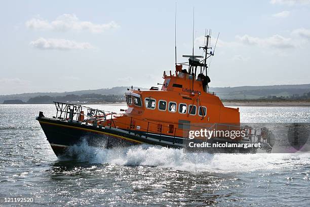 coast guard boat moving quickly through the sea - red boot stockfoto's en -beelden