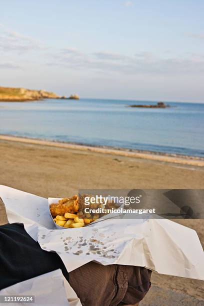 eating fish and chips on the beach - chips on paper stock pictures, royalty-free photos & images