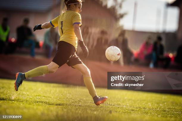 teenage soccer goalie kicking the ball on a sports training at stadium. - women's football stock pictures, royalty-free photos & images