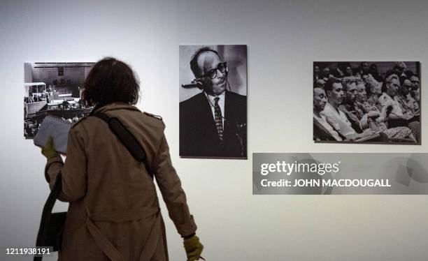 Visitor walks past a portrait of Nazi war criminal Adolf Eichmann during his trial in Jerusalem at an exhibition on German-American philosopher and...