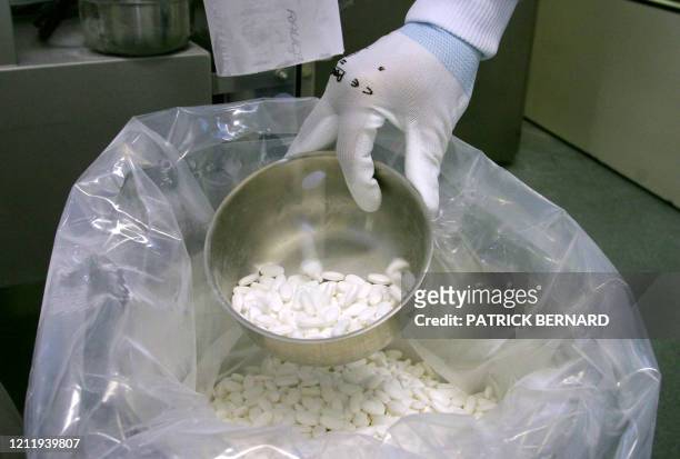 Un employé du laboratoire Sanofi-Synthélabo d'Ambares contrôle la qualité de comprimés issus d'une chaîne de fabrication de médicaments le 16...