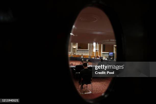 Judge Justin Walker is seen through the glass window of a closed door as he testifies before just a few senators during his U.S. Senate Judiciary...