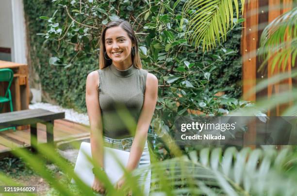 smiling young brazilian businesswoman with laptop - founder stock pictures, royalty-free photos & images