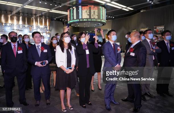 People wearing face masks attend the listing ceremony of of Ximei Resources Holding Ltd, Deep Blue Technology Co,Ltd, Cirtek Holdings Ltd and Wei...