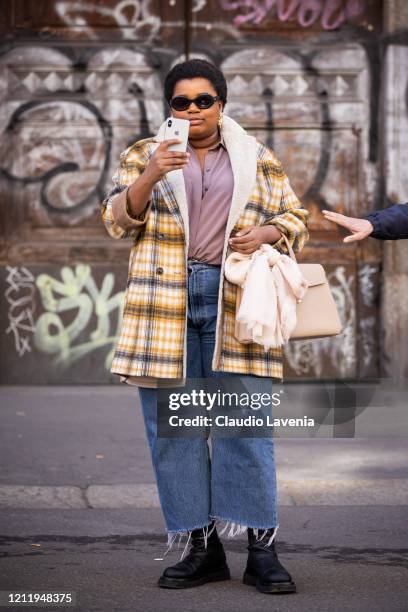 Gabriella Karefa Johnson, wearing a pink shirt, jeans, black boots, cream bag and checked jacket, is seen outside Agnona show, during Milan Fashion...