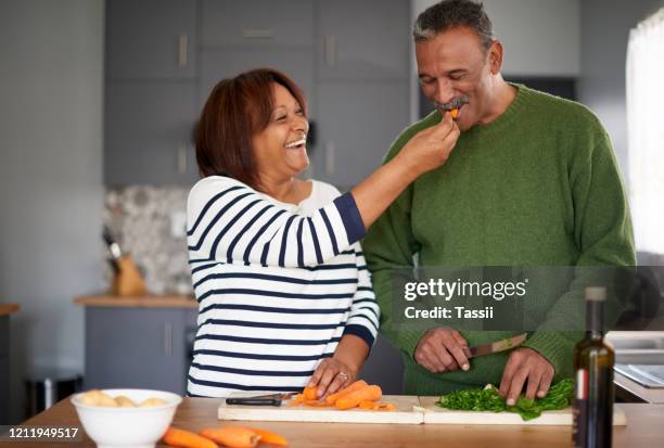 最初に味わってみてはいかがですか - middle aged couple cooking ストックフォトと画像
