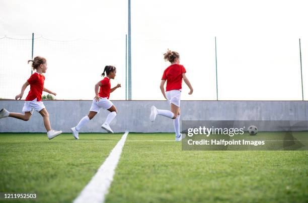 a group of children with coach training on football pitch. - football pitch bildbanksfoton och bilder