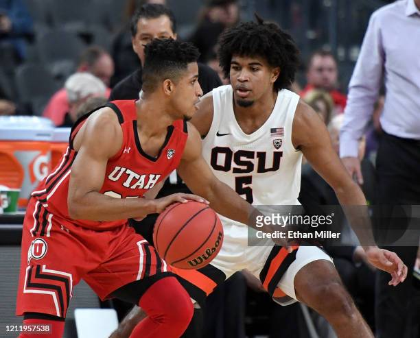 Ethan Thompson of the Oregon State Beavers guards Alfonso Plummer of the Utah Utes during the first round of the Pac-12 Conference basketball...