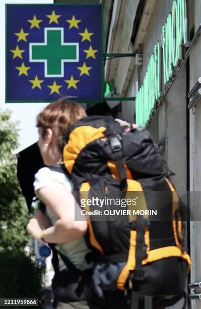 Une touriste passe devant une pharmacie à l'effigie européenne le 25 juin 2007, dans le centre de Strasbourg. Se faire rembourser des soins réalisés...