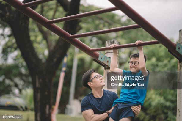 一位亞洲華裔運動員在公園訓練他12歲的兒子，晚上升降吧 - 12 13 years 個照片及圖片檔