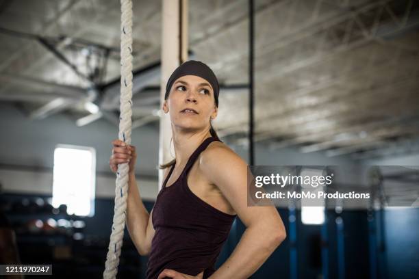 woman using climbing rope at cross training gym - momo challenge stock pictures, royalty-free photos & images