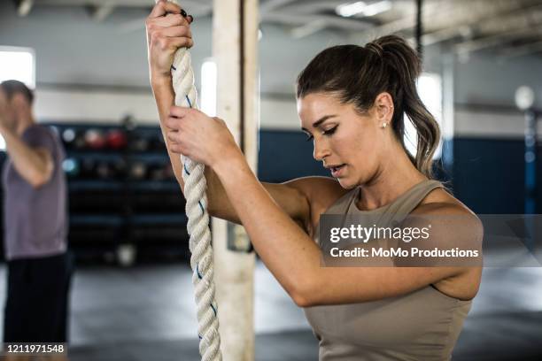 woman using climbing rope at cross training gym - momo challenge stock pictures, royalty-free photos & images