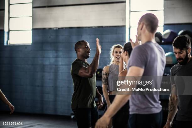 people hi-fiving after cross training class - black man high 5 stock pictures, royalty-free photos & images
