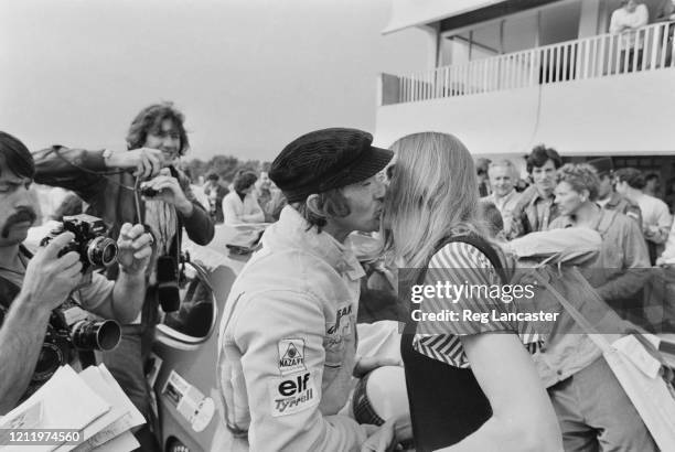 British Formula One racing driver Jackie Stewart kisses his wife, Helen, as photographers capture the moment, at the Circuit Paul Ricard, where...