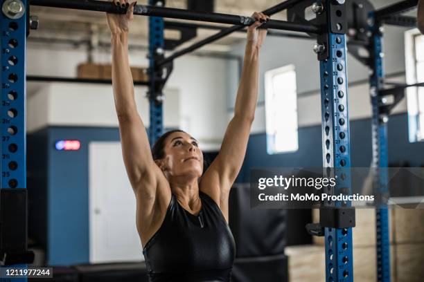 woman doing pullups at cross training gym - black female bodybuilder stock pictures, royalty-free photos & images