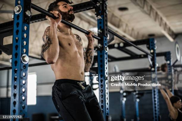 man doing pullups at cross training gym - pull ups stock pictures, royalty-free photos & images
