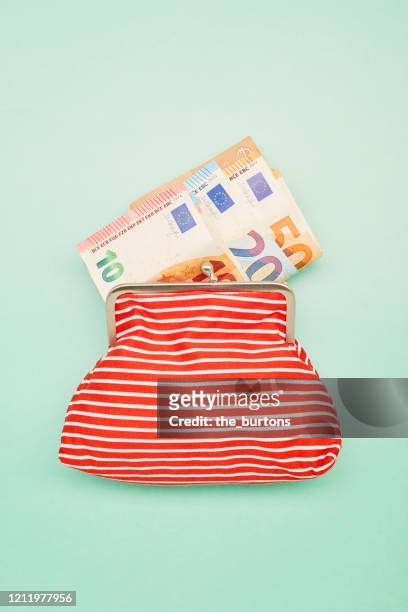 directly above shot of a wallet and euro banknotes on turquoise background - blue purse fotografías e imágenes de stock
