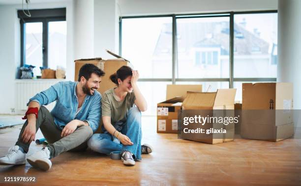 young couple moving in together. - sitting on ground stock pictures, royalty-free photos & images