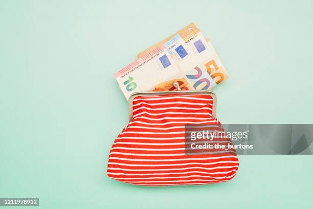 directly above shot of a wallet and euro banknotes on turquoise background - wages stock-fotos und bilder