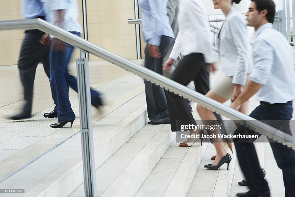 Busy business people ascending on office stairs