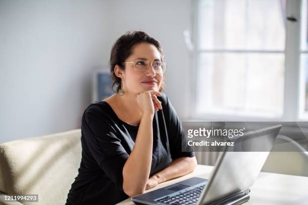 geschäftsfrau denkt während der arbeit im büro - beschaulichkeit stock-fotos und bilder