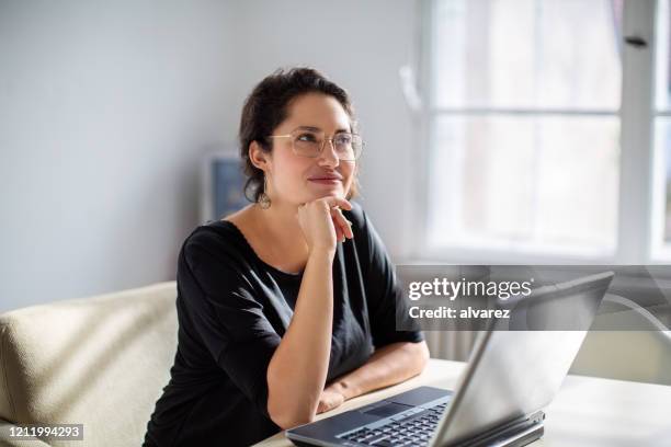 businesswoman thinking while working in office - reflective imagens e fotografias de stock