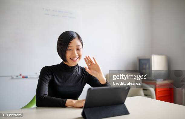 female professional making a video call in office - waving gesture stock pictures, royalty-free photos & images