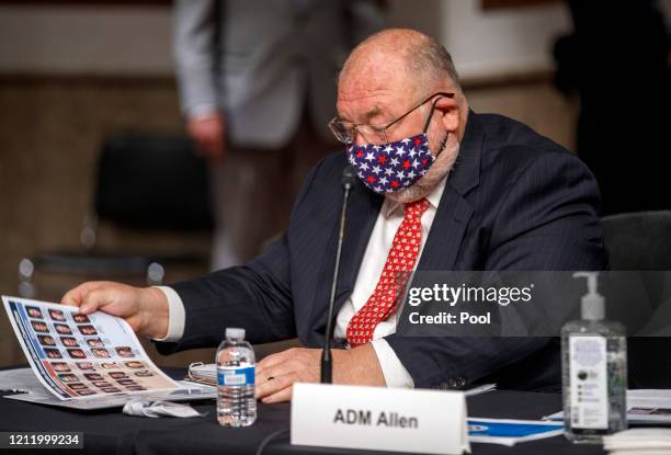 Retired United States Coast Guard Admiral Thad W. Allen wears a mask as he prepares to testify before the Senate Armed Services Committee hearing on...