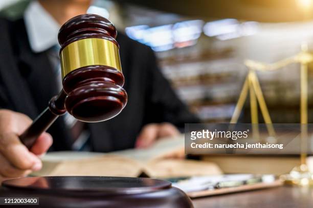 close up of judge holding gavel - gerechtigheid stockfoto's en -beelden