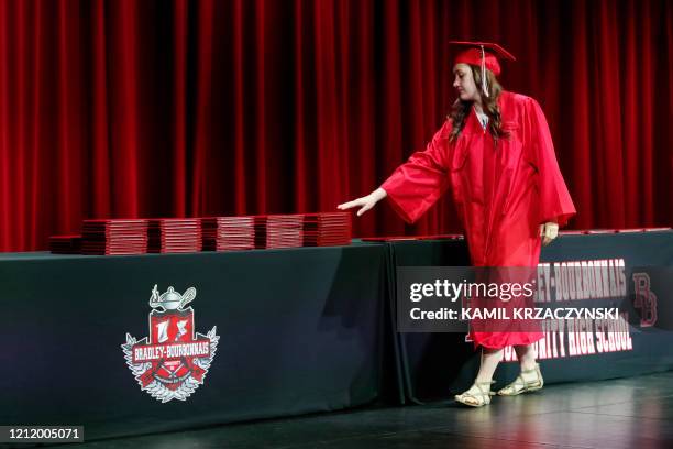Student picks up her diploma during a graduation ceremony at Bradley-Bourbonnais Community High School on May 6, 2020 in Bradley, Illinois. - A...