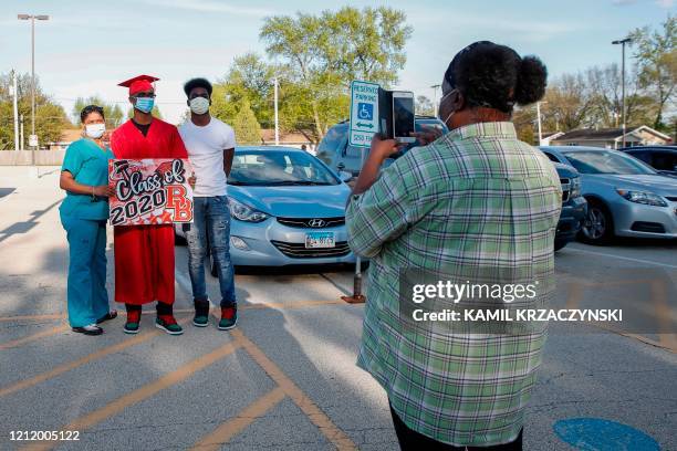 Student Wincent Williams poses for a picture with family members outside Bradley-Bourbonnais Community High School after picking up his diploma...