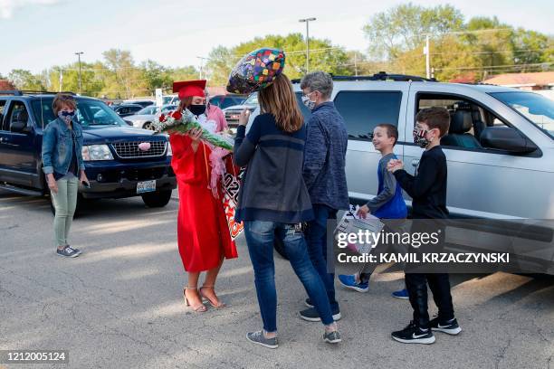 Student Mia Wiley is congratulated by family members after picking up her diploma during a graduation ceremony at Bradley-Bourbonnais Community High...