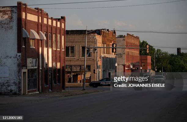 Police car drives through the Main Street of Cushing, where many crude oil storage facilities are located on May 4, 2020 in Cushing, Oklahoma. Using...