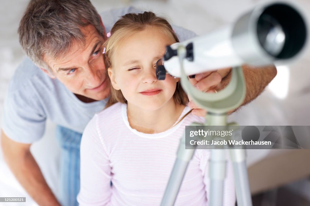 Hübsches Mädchen Blick in den Himmel durch ein Teleskop mit ihrem Vater