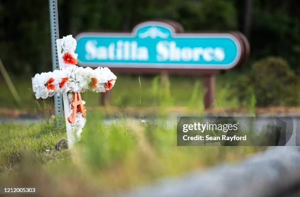 Cross with flowers and a letter "A" sits at the entrance to the Satilla Shores neighborhood where Ahmaud Arbery was shot and killed on May 6, 2020 in...