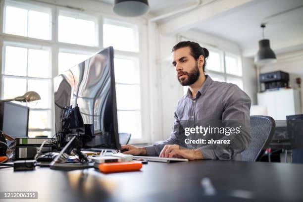 programador informático trabajando en su escritorio - europeo del norte fotografías e imágenes de stock