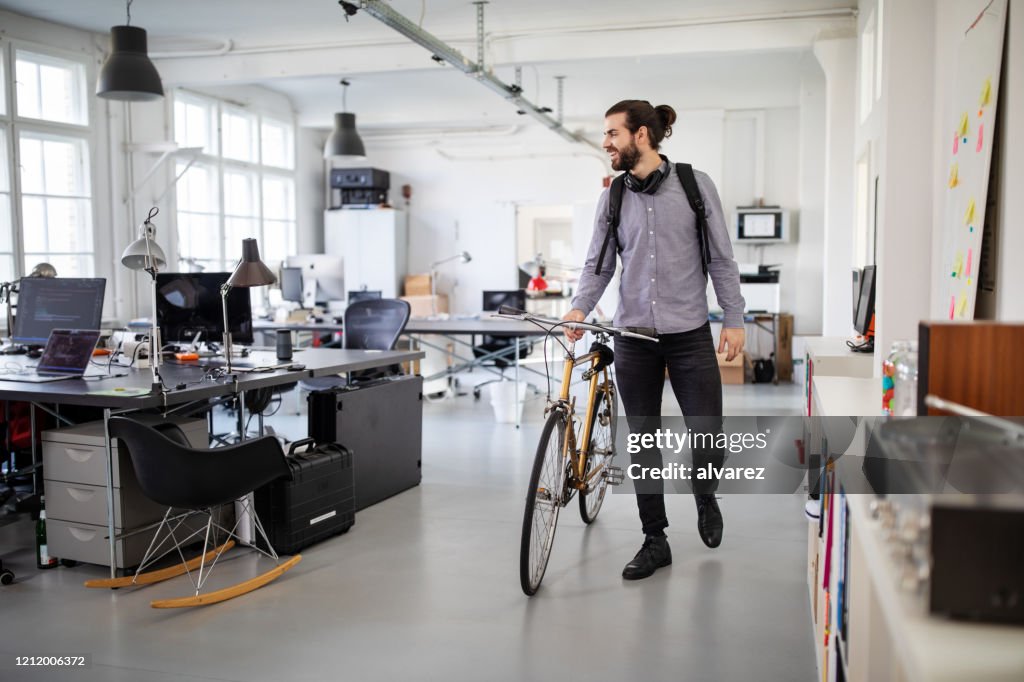 Uomo d'affari con bicicletta in ufficio