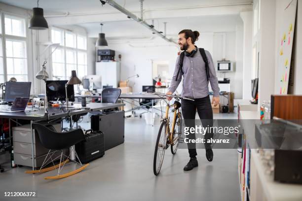 businessman with a bicycle in office - chegada imagens e fotografias de stock