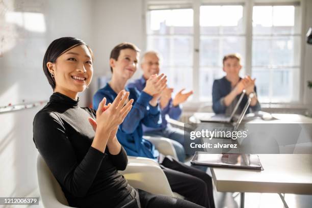 business professionals clapping hands in a meeting - clapping hands office stock pictures, royalty-free photos & images