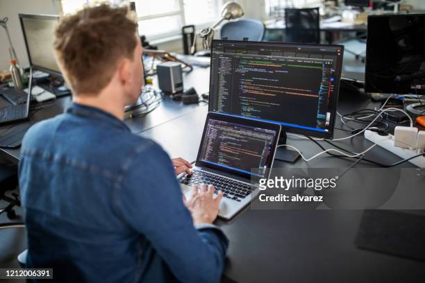 programmatore di computer che lavora a un nuovo programma software - solo un uomo di età media foto e immagini stock