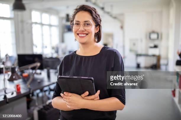 geschäftsfrau hält ein digitales tablet im büro - in den dreißigern stock-fotos und bilder