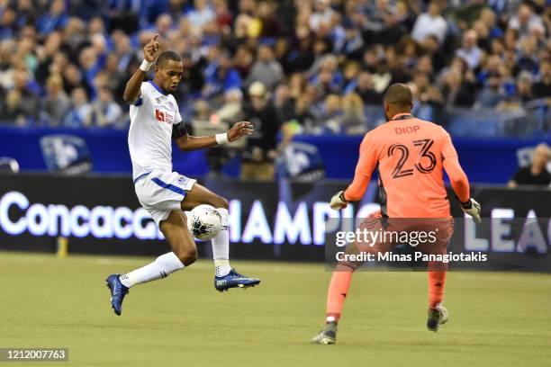 Jerry Bengtson of CD Olimpia runs the ball towards goalkeeper Clement Diop of the Montreal Impact in the first half during the 1st leg of the...